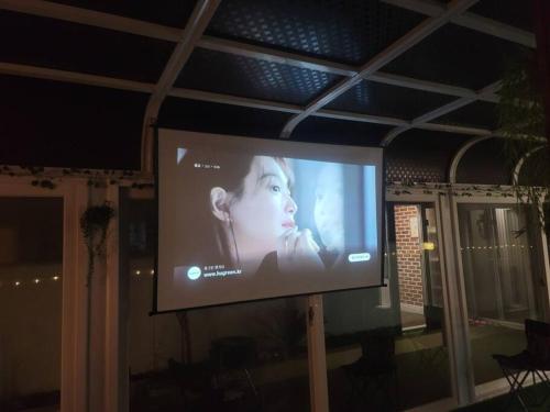 Ein großer TV-Bildschirm mit einer Frau drauf. in der Unterkunft Hello minbak in Boseong
