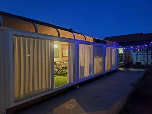 a house with sliding glass doors on a balcony at night at Hello minbak in Boseong