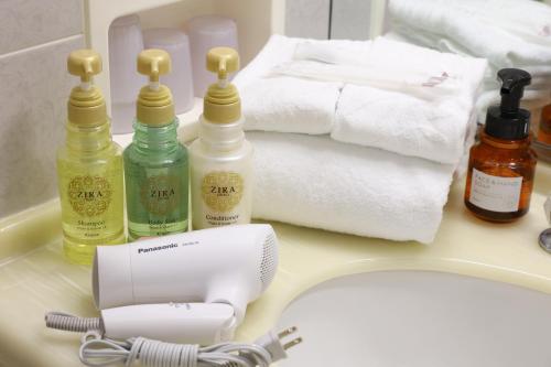 a bathroom sink with hygiene products on a counter at Hotel Springs Makuhari in Chiba