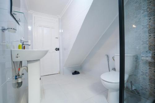 a white bathroom with a toilet and a sink at DAR AMR in Tangier