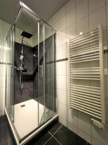 une douche avec une porte vitrée dans une salle de bain dans l'établissement L'instant Moderne Centre-ville Parking Gratuit, à Béziers