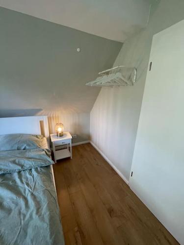 UnterlüßにあるFerienwohnung am Wald in der Südheideのベッドルーム1室(ベッド1台、サイドテーブル付)