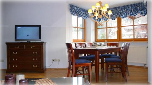 a dining room with a table and chairs and a television at Florian in Garmisch-Partenkirchen