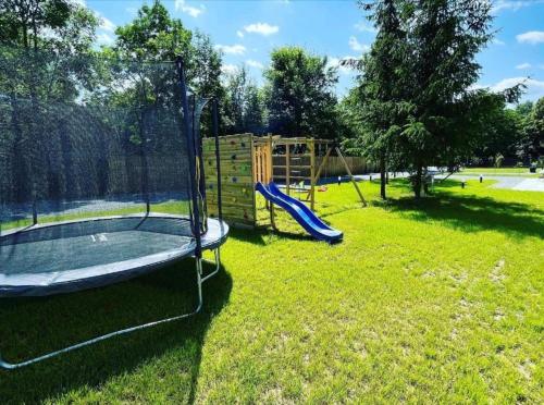 a playground with a slide in the grass at Mokre 22 in Bielsk Podlaski
