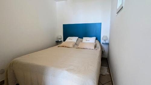 une chambre avec un lit avec deux oreillers dessus dans l'établissement 050 Plein sud - Bel appartement rez de chaussée avec pk et wifi, au Cap d'Agde
