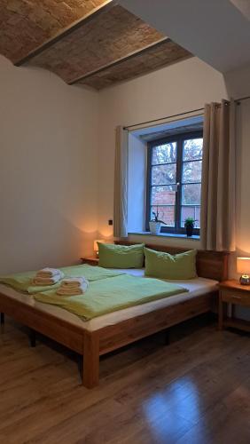 ein großes Bett in einem Zimmer mit Fenster in der Unterkunft FerienRemise in Brandenburg an der Havel