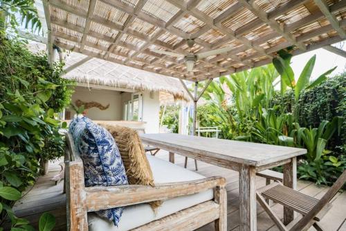 a patio with a wooden table and a wooden pergola at Villa Sari Nusa Lembongan - Three bedroom Villa in Nusa Lembongan