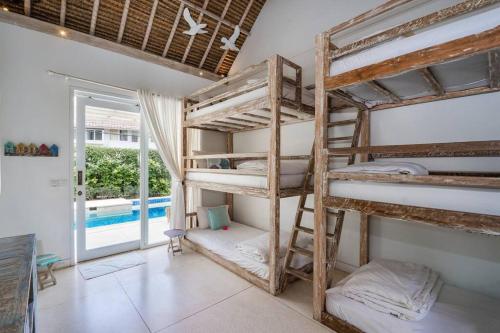 a room with two bunk beds and a pool at Villa Sari Nusa Lembongan - Three bedroom Villa in Nusa Lembongan
