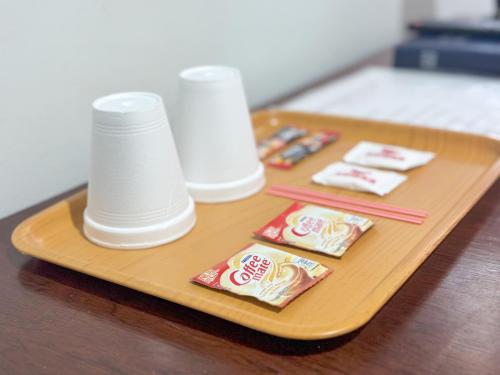 ein Tablett mit Essstäbchen und Lebensmittelpaketen auf dem Tisch in der Unterkunft Gplace Hotel in Cebu City