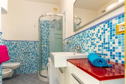 uma casa de banho com um lavatório e um chuveiro em Appartamento Borgo Mari PT5 - MyHo Casa em Santa Teresa Gallura