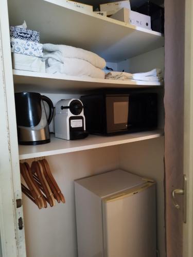 une étagère de cuisine avec un grille-pain et un four micro-ondes dans l'établissement Studio cosy proche aéroport d'Orly & paris, à Paray-Vieille-Poste