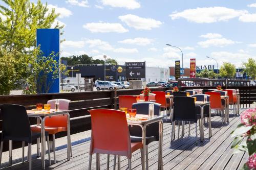 a row of tables and chairs on a patio at FH Confort Hotel Orléans Co'met in Orléans