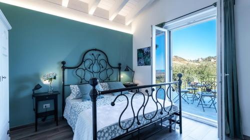 sypialnia z łóżkiem i balkonem w obiekcie DIMORA CAMPO DELLE MURA 4&2, Emma Villas w mieście Acquaviva Picena