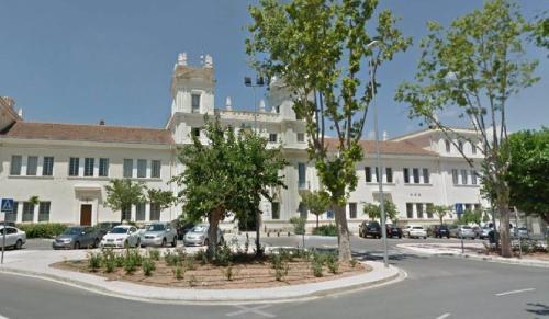 um grande edifício branco com uma torre de relógio em LC Apartaments Hospital General em Castellón de la Plana