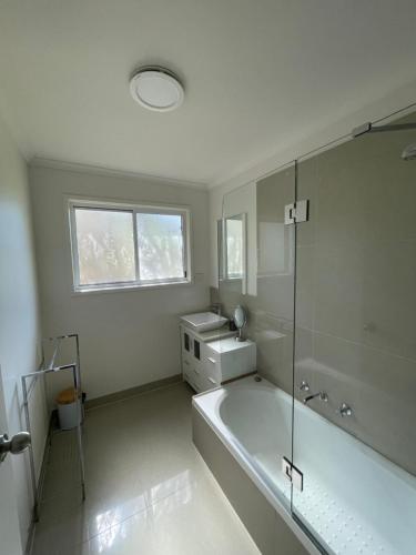 ein weißes Badezimmer mit einer Badewanne und einem Waschbecken in der Unterkunft Cowes Holiday Home in Cowes