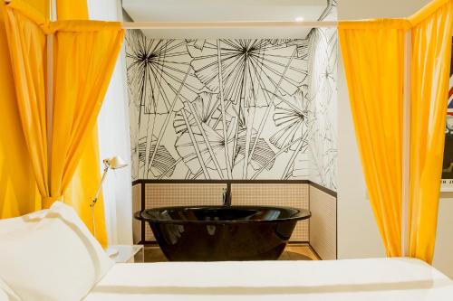 a black tub in a room with orange curtains at Palazzo Segreti in Milan