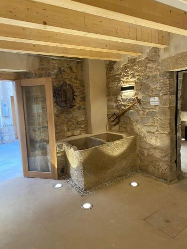 a room with a stone wall and a stone tub at Cal Vallverdú - Adaptado in Preixana