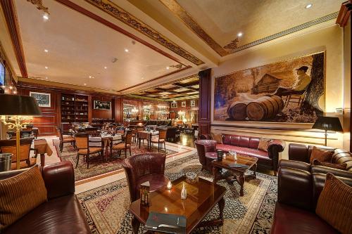 a restaurant with couches and tables and a painting on the wall at Royal Ascot Hotel in Dubai