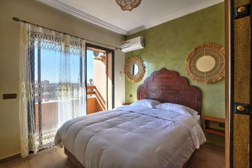 - une chambre avec un grand lit et une grande fenêtre dans l'établissement Nour 5 el bellar, à Marrakech