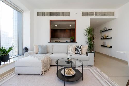 a living room with a couch and a table at Prestige Living 2BR with Full Burj Khalifa and Fountain View by Auberge in Dubai