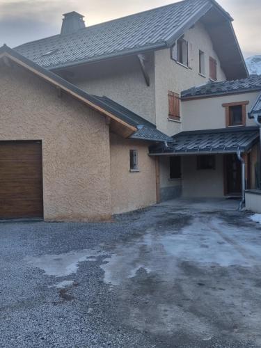 une maison avec un parking à côté d'un garage dans l'établissement Maison + jardin vue sur les montagnes, à Barcelonnette