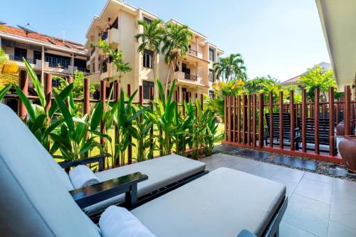 a balcony with a couch and a table and a building at HOI AN HISTORIC HOTEL in Hoi An