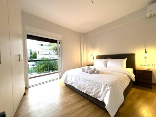 una camera con un grande letto e una grande finestra di 2-Bed Gem in Serene Locale ad Atene