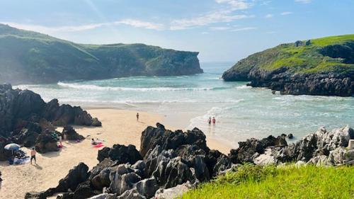 a group of people on a beach near the water at APARTAMENTOS RURALES El Llagar de Cue in Llanes
