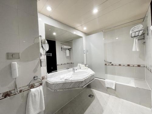 a white bathroom with a sink and a mirror at Grand Oasis Resort in Sharm El Sheikh