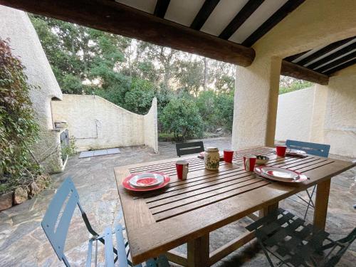 une table en bois avec des assiettes et des tasses sur une terrasse dans l'établissement Mini villa Porto, Santa Giulia, à Porto-Vecchio