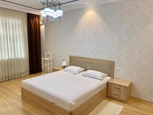 um quarto com uma cama grande e um lustre em Spacious Apartment in New Building, Near the City Center and Airport em Tashkent
