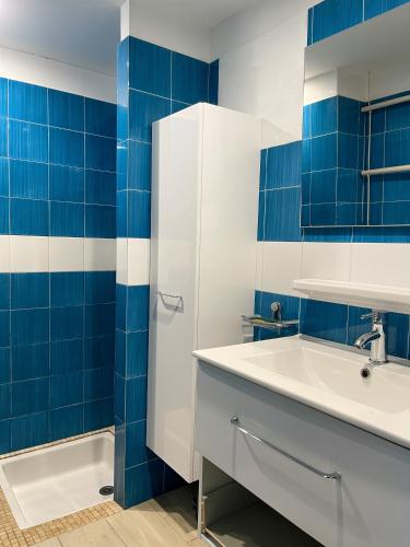 La salle de bains est pourvue d'un lavabo et de carrelage bleu. dans l'établissement Mini villa Porto, Santa Giulia, à Porto-Vecchio