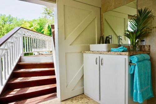 baño con una puerta que conduce a una escalera en Lovely 3 BR Ocean View Villa en Cap Estate