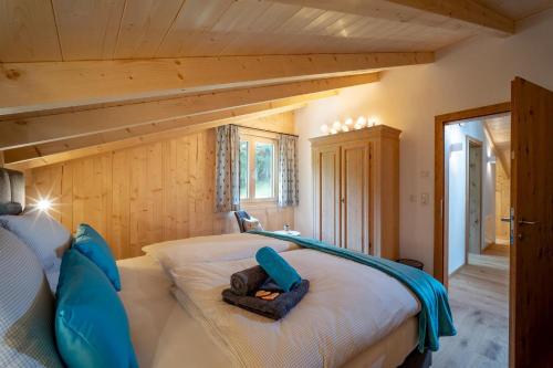 a bedroom with a bed with blue pillows on it at Chalet Alpenherz in Kirchberg in Tirol