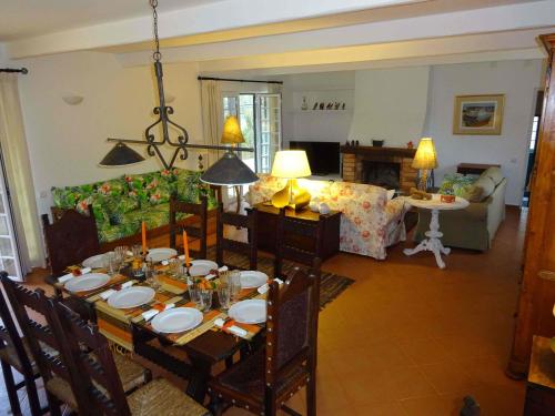 a living room with a table with chairs and a couch at Casa das Xaras in Sintra