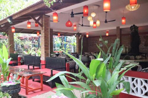 een patio met stoelen, tafels en verlichting bij La Niche D'angkor Boutique Hotel in Siem Reap