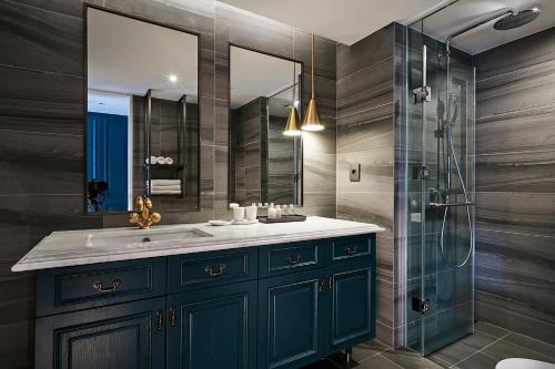 a bathroom with a blue sink and a shower at The Suites Hotel Jeju in Seogwipo