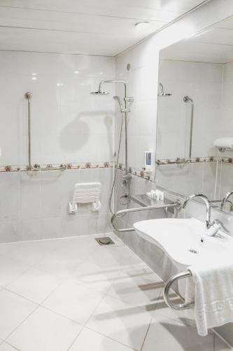 a white bathroom with a sink and a mirror at Grand Oasis Resort in Sharm El Sheikh
