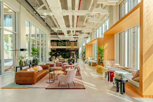 a lobby with couches and tables and windows at First Class Apartments in Dubai Hills - Next to Dubai Hills Mall - Socio, Collective and Golfville Towers in Dubai