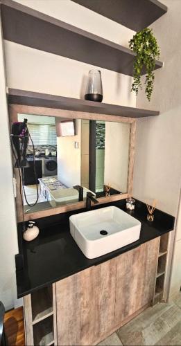 a bathroom with a white sink and a mirror at De Oude Sleeper Inn 1 Flat in Kimberley