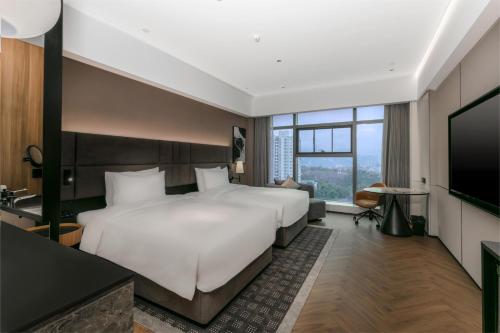 Habitación de hotel con cama grande y TV en Intercity Renhuai, en Zunyi