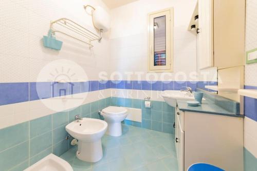 ein blau-weißes Badezimmer mit 2 WCs und einem Waschbecken in der Unterkunft Casa Mimy (Piano Terra) - 700 mt dal mare in Porto Cesareo