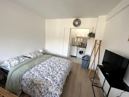 une chambre avec un lit et une télévision à écran plat dans l'établissement Studio cozy proche Paris, à Gentilly