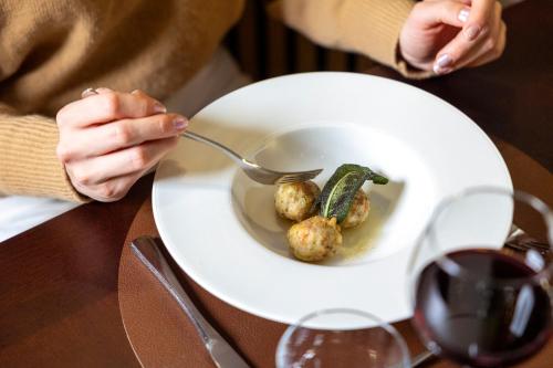 a person sitting at a table with a plate of food at Hotel Derby in Folgarida
