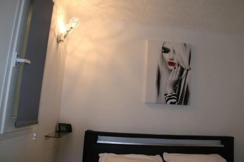 une chambre avec une photo d'une femme sur le mur dans l'établissement Appart 108, Port Soleil au village naturiste, au Cap d'Agde