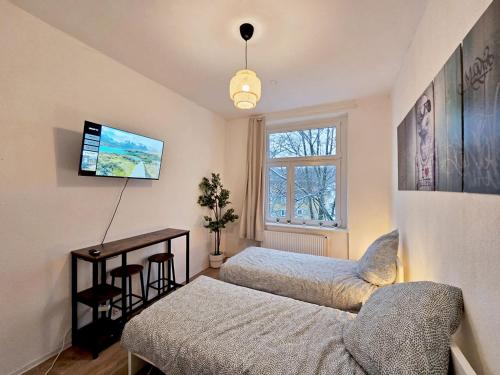 een slaapkamer met 2 bedden, een bureau en een raam bij Nice Apartment in Wuppertal in Wuppertal