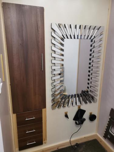 a wall with a mirror and a rack of wine bottles at The Comfy House in Huddersfield