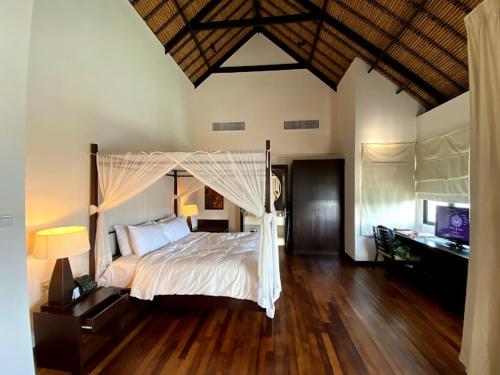 a bedroom with a large bed with a canopy at Avani Sepang Goldcoast Resort Family Villa in Bagan Lalang