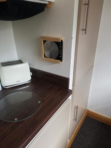 a small kitchen with a sink and a microwave at The Comfy House in Huddersfield