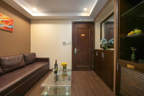 a living room with a couch and a glass table at Brilliant Me Tri Hotel in Hanoi